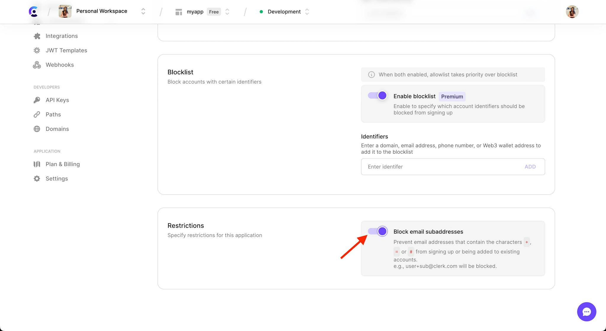 The 'Restrictions' section in the 'Restrictions' tab under the 'User & Authentication' section of the Clerk Dashboard. A red arrow is pointing to the 'Block email subaddresses' toggle, which is toggled on.